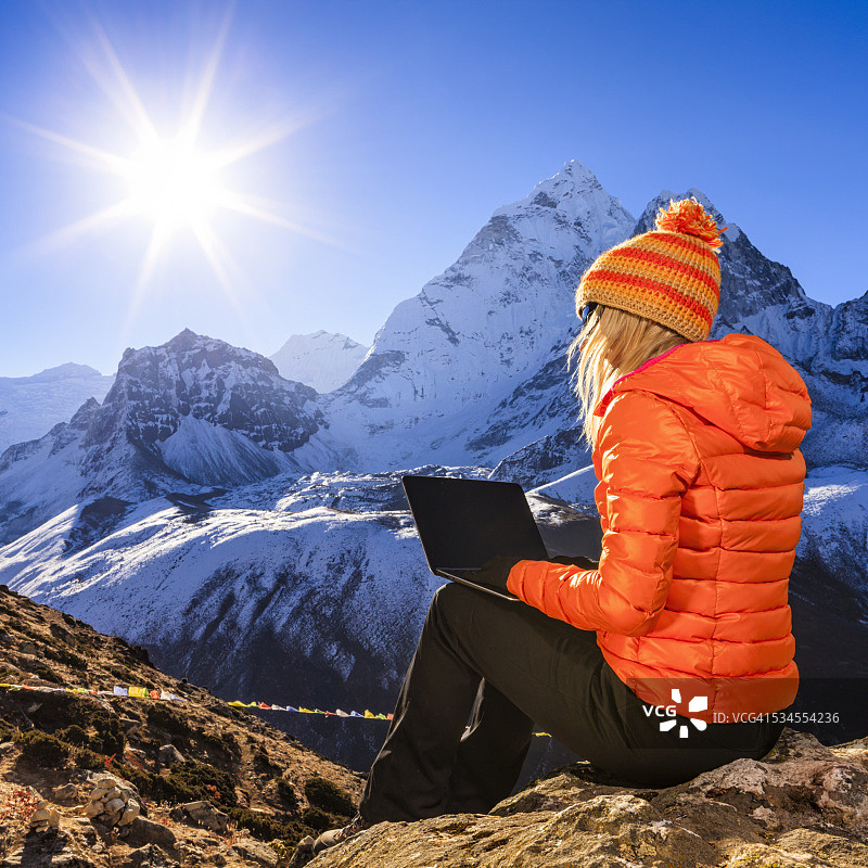 年轻女人在尼泊尔喜马拉雅山脉使用笔记本电脑图片素材