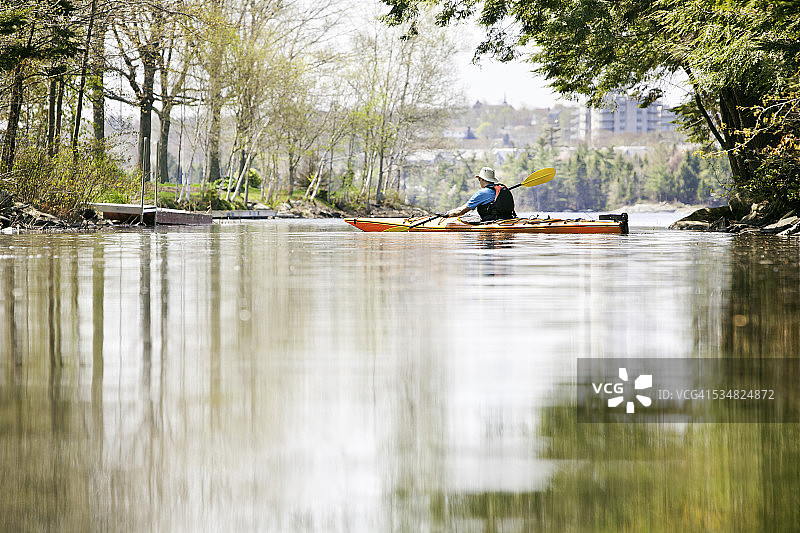 男人在平静的水中划皮划艇图片素材