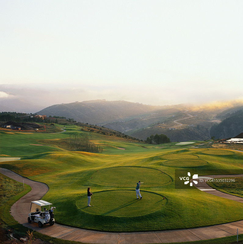 日出时分挥杆的高尔夫球手图片素材