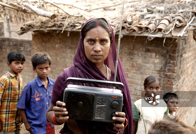 在印度贾坎德邦加尔瓦和拉特哈，女人拿着一台收音机图片素材