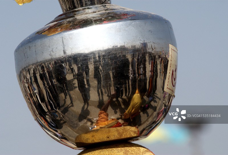 印度北方邦阿拉哈巴德 अर्ध कुंभ 节期间，不锈钢罐上信徒的倒影图片素材