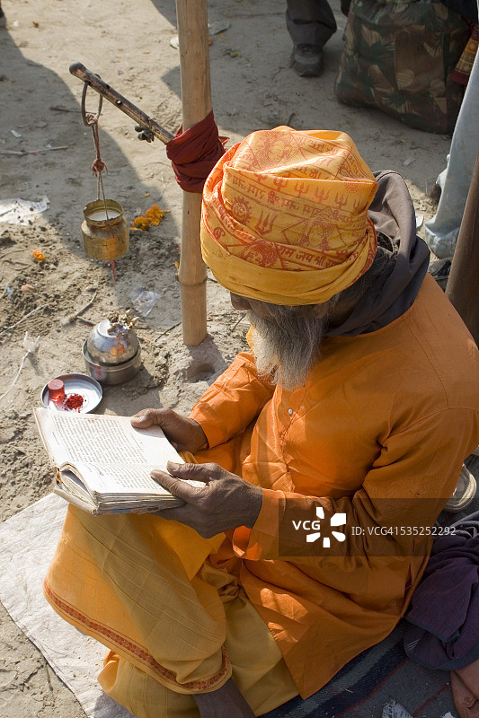 印度北方邦阿拉哈巴德昆梅拉节期间阅读圣书的印度教男子图片素材