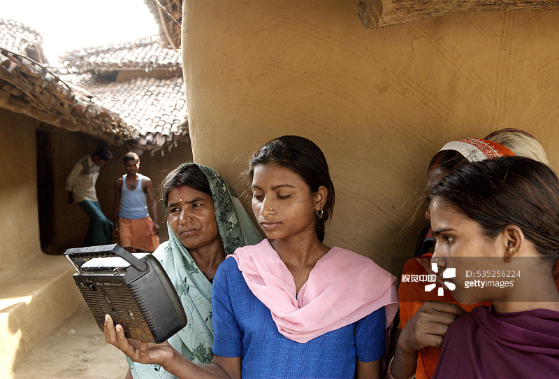 在印度贾坎德邦加尔瓦和拉特哈尔收听收音机的妇女图片素材