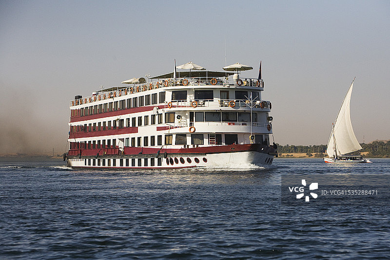 尼罗河上的三角帆船和污染的游轮图片素材