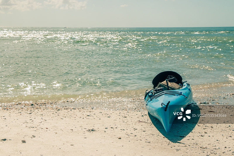 热带海滩上的蓝绿色皮划艇图片素材