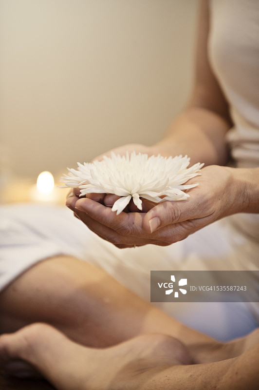 女人冥想时拿着花图片素材