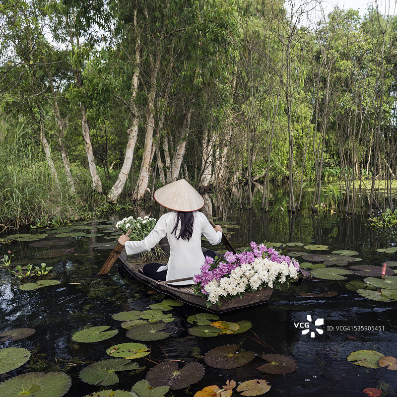 女人划着载满鲜花的船图片素材
