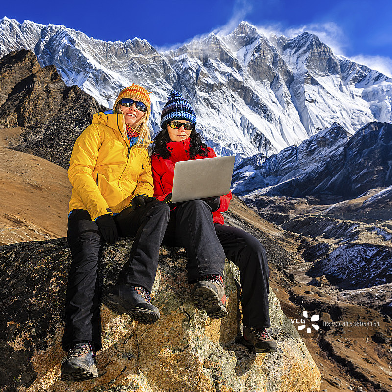 年轻女人在尼泊尔喜马拉雅山使用笔记本电脑图片素材
