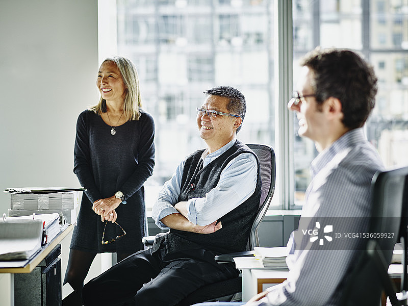 团队会议中笑容满面的中年商人图片素材