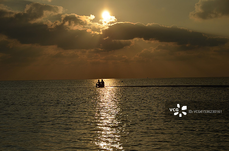 情侣在沙滩上看日落图片素材