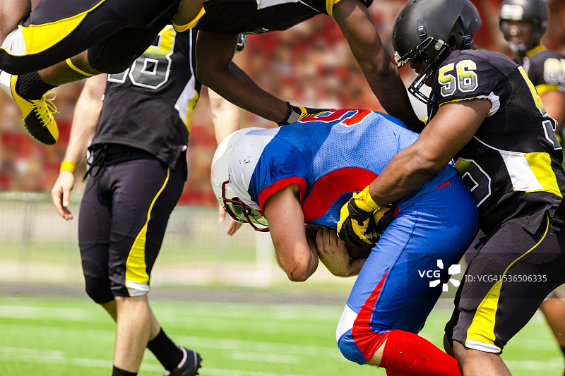 橄榄球队的跑卫带球。后卫。体育场球迷。场地。图片素材