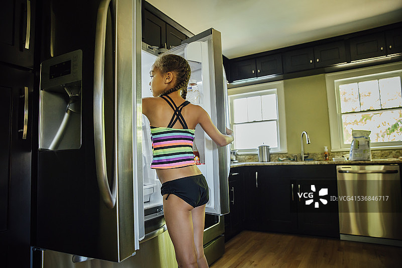 女孩从冰箱里拿食物图片素材