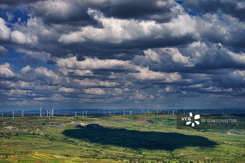 云彩在风力发电场的地面上投下阴影图片素材