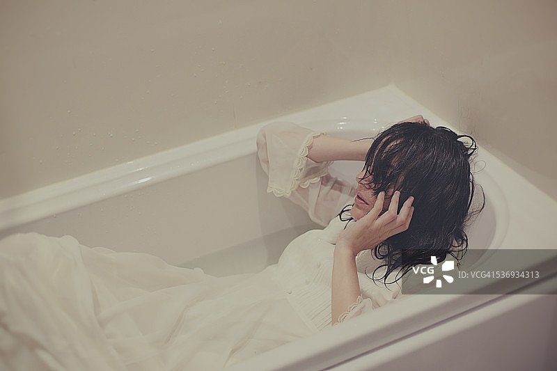 身穿白色连衣裙在浴缸里的女孩图片素材