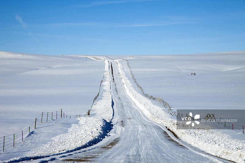 雪覆盖的乡村公路的视角图片素材
