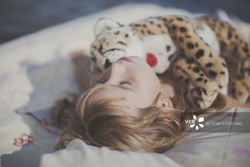 女孩抱着毛绒玩具睡觉图片素材