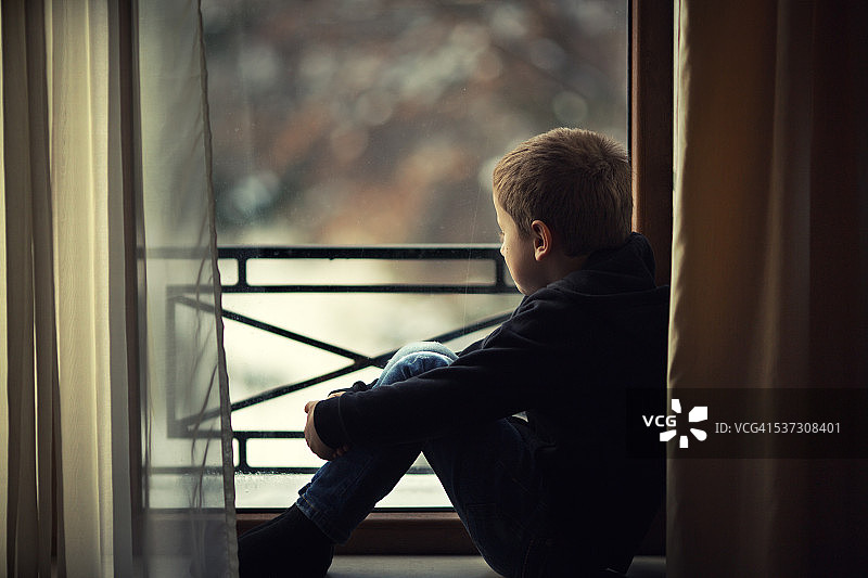 男孩向窗外看图片素材