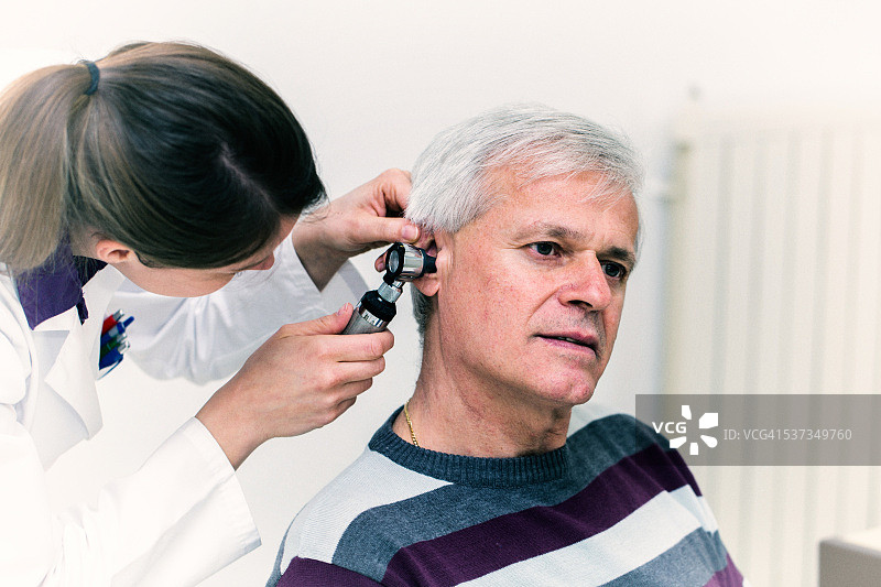 年轻女医生用耳镜检查病人耳朵图片素材