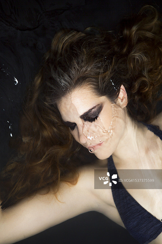 年轻女子几乎被水淹没图片素材