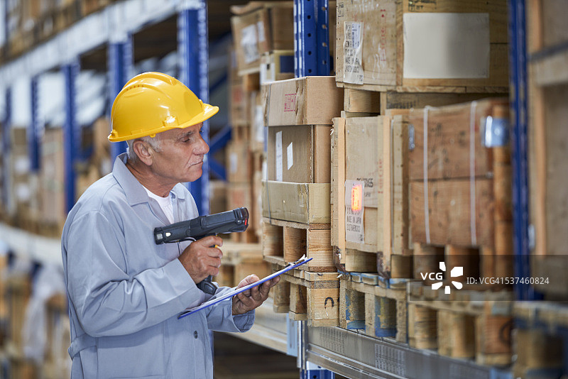 工人在仓库用条形码终端检查存储图片素材