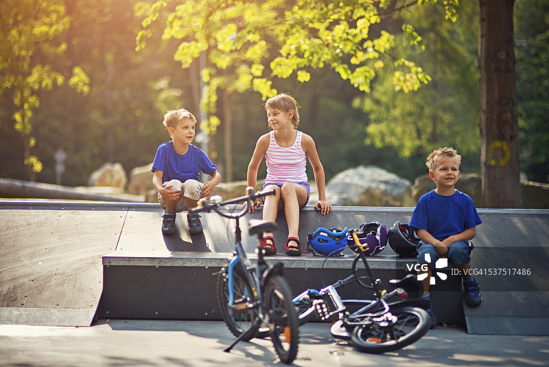 孩子们在坡道上骑自行车后休息图片素材