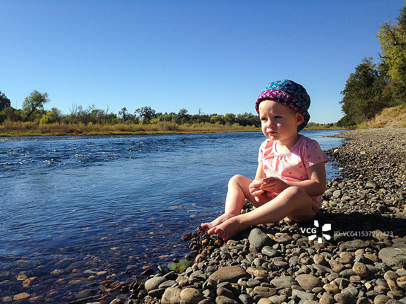 坐在河岸边的女婴图片素材