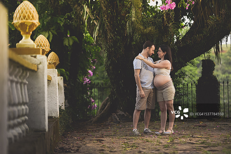 情侣在乡村花园里拥抱，期待宝宝的到来图片素材