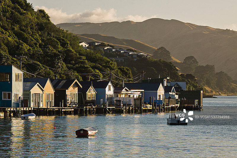 Pauatahanui河口的船棚沐浴在清晨阳光中图片素材