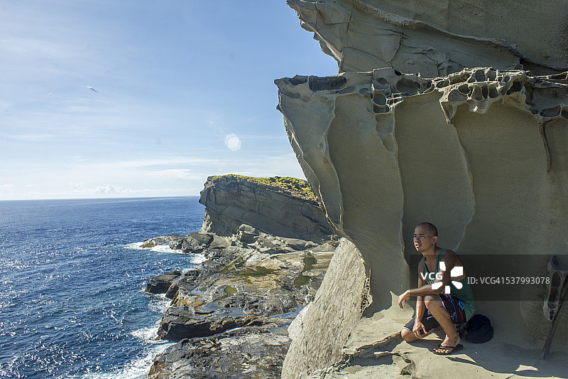 男人在巨石阴影下休息图片素材