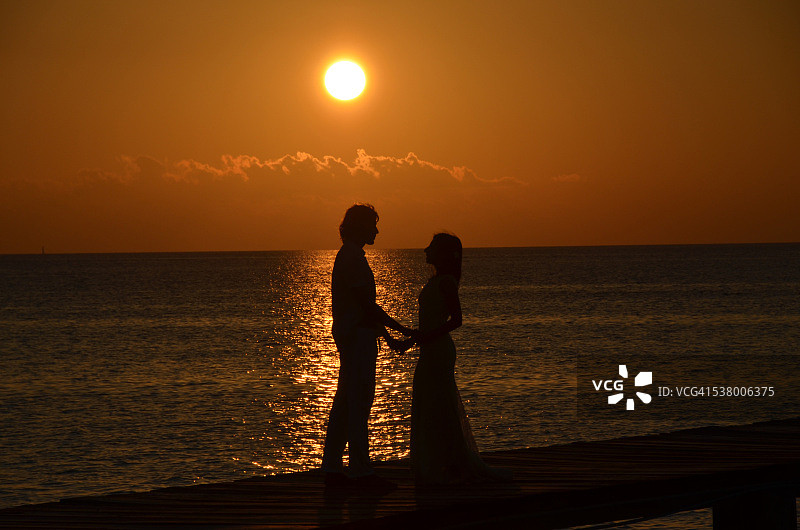 日落时浪漫情侣的轮廓图片素材