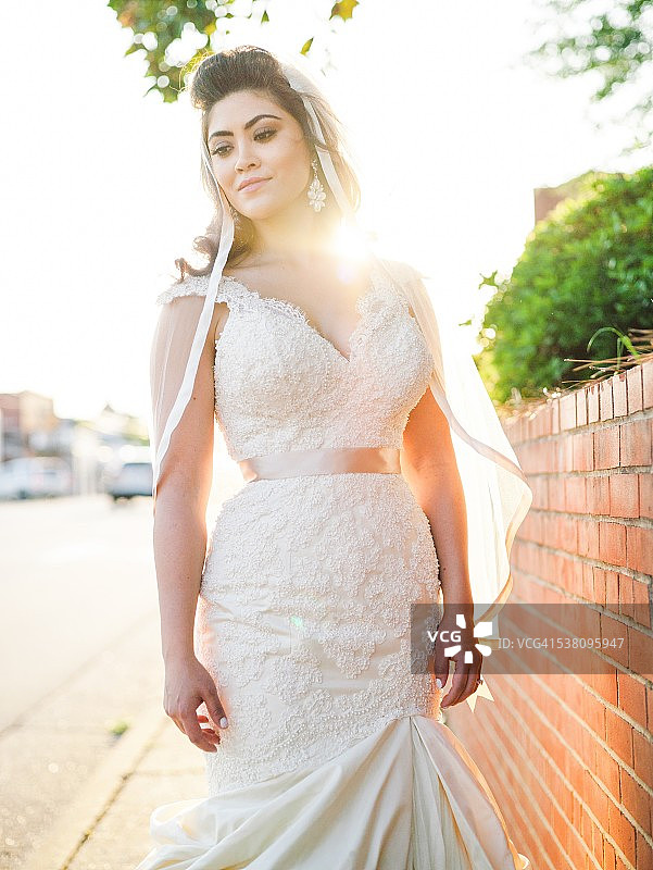 新娘穿着白色婚纱在户外摆姿势图片素材