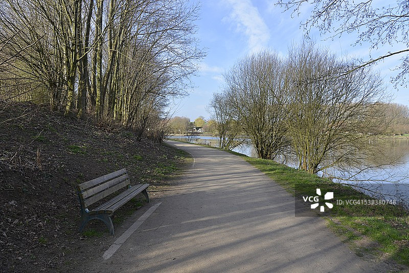 主池塘边阴影中的长椅图片素材