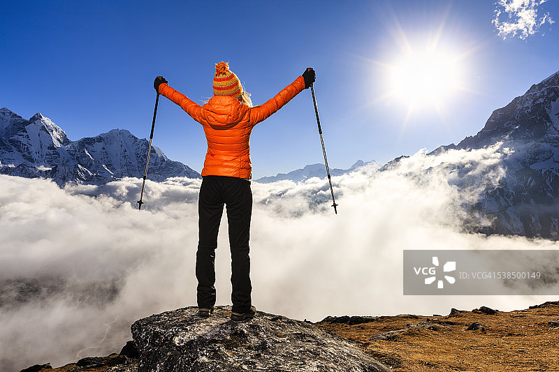 在喜马拉雅山脉中举起双臂欢呼的女人图片素材