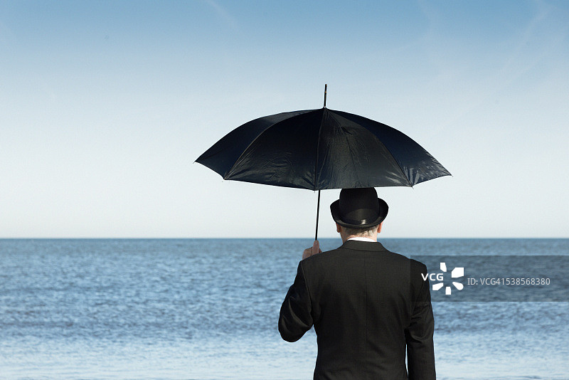 站在海滩上眺望大海的英国男人图片素材