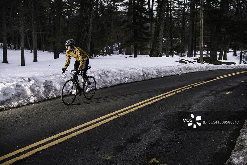 公路自行车手在冬季景观中骑行图片素材