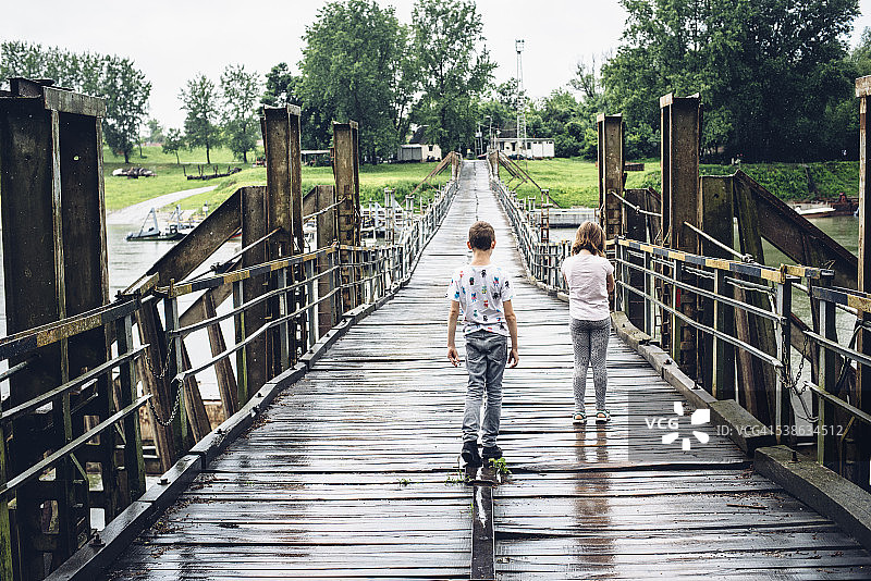 在匈牙利蒂萨河上浮桥上的男孩和女孩图片素材