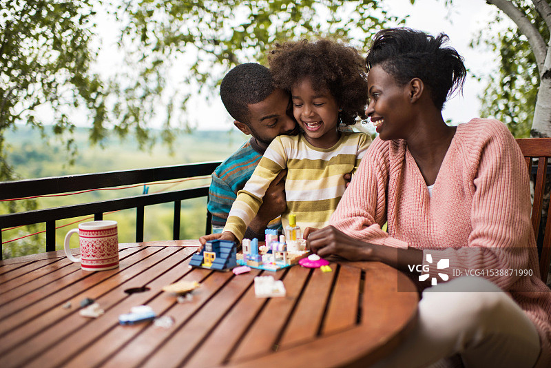 快乐的非裔美国家庭在露台上玩耍。图片素材