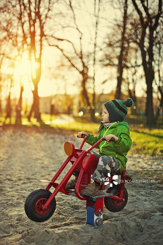 小男孩坐在摩托车上梦想着高速公路图片素材