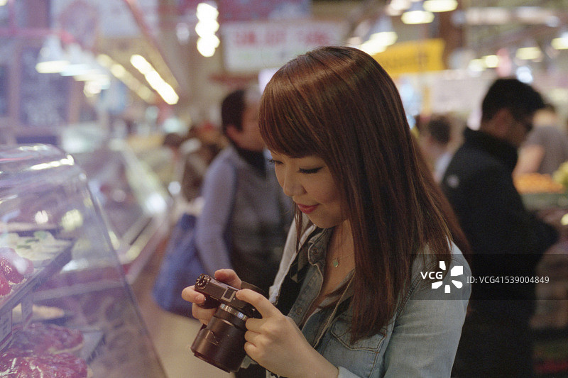 女孩看着她的相机图片素材