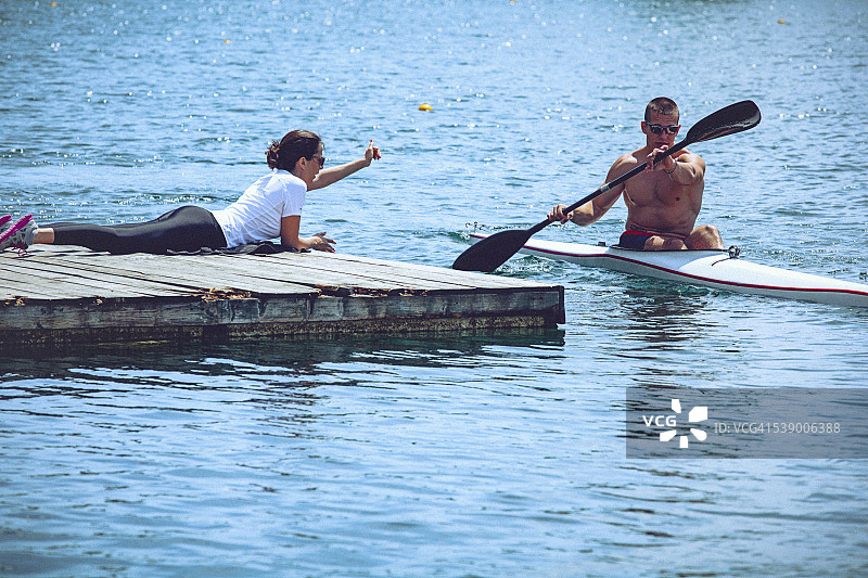 皮划艇短跑训练中指导年轻男运动员的女教练图片素材