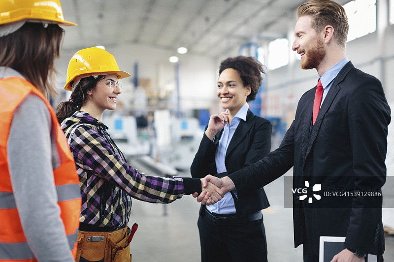 质量检验员与工人握手图片素材