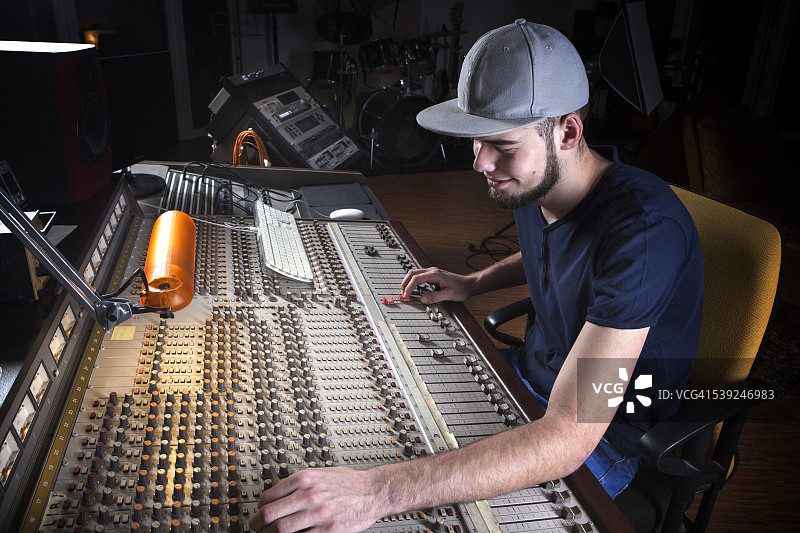 男录音师在工作室使用调音台图片素材