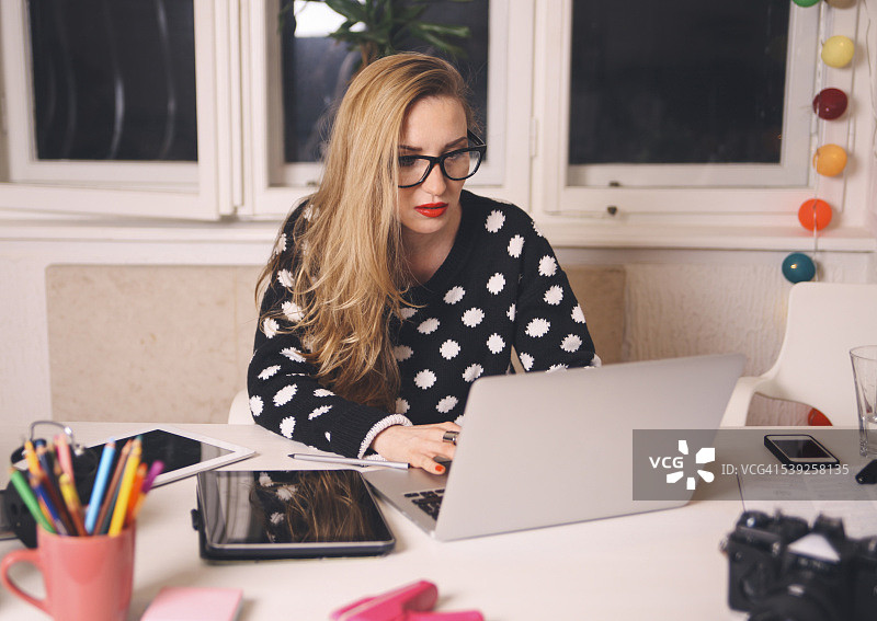 在办公室工作到深夜的年轻时尚设计师图片素材