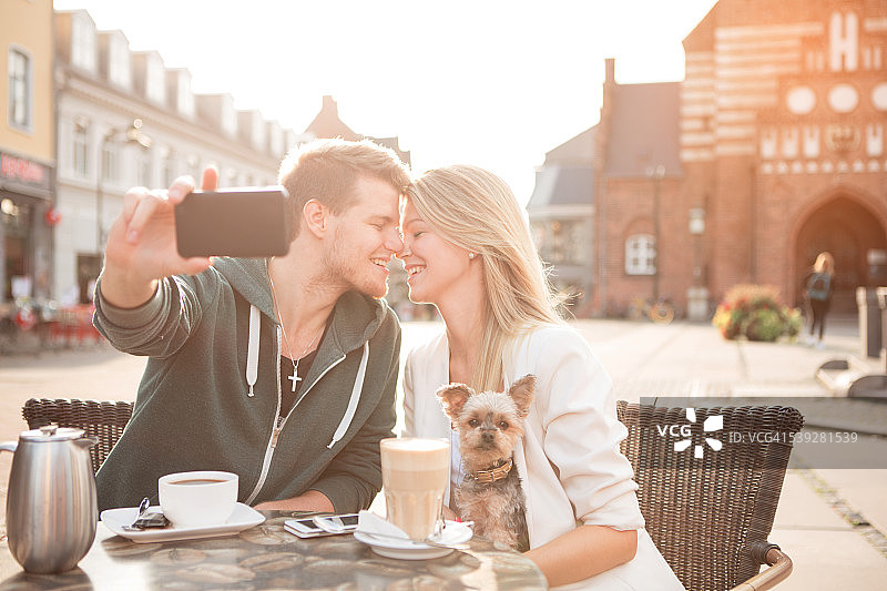 年轻情侣和他们的狗在咖啡馆图片素材