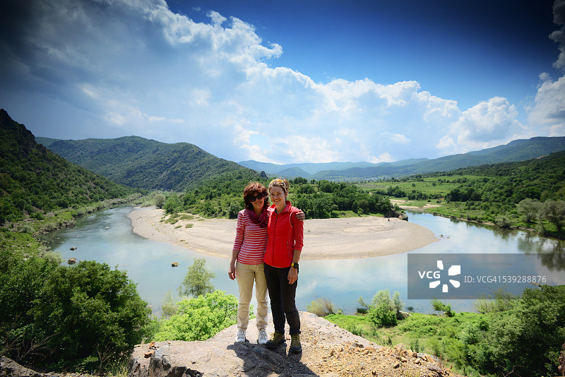 母女站在蜿蜒的河边图片素材