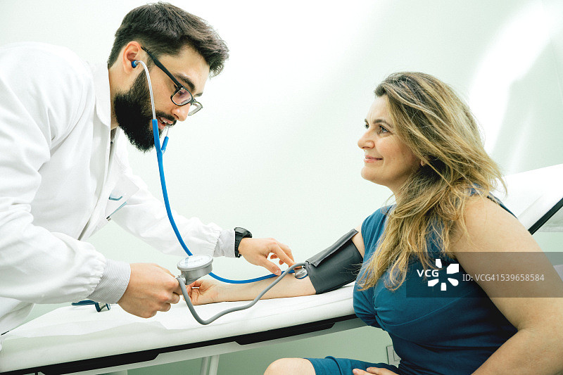 测量血压的年轻男医生图片素材