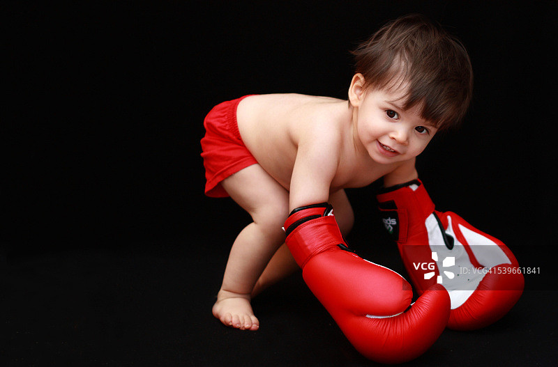 戴着拳击手套的男婴（18-23个月）图片素材