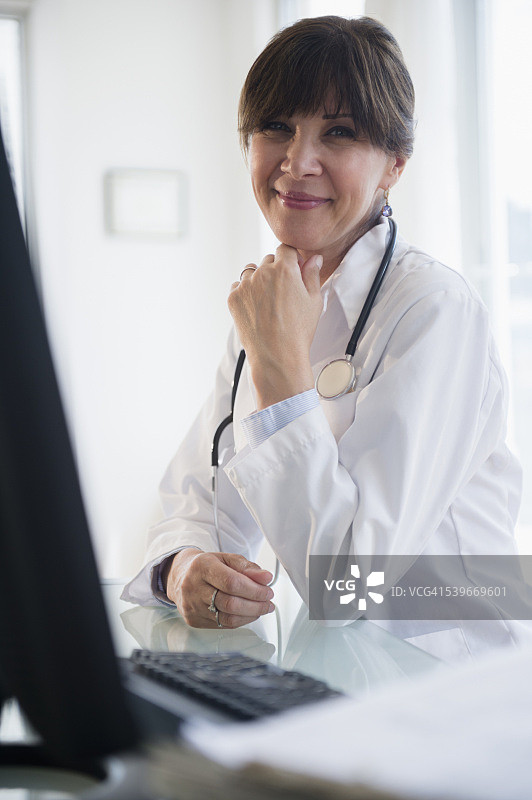 美国新泽西州，医生坐在办公桌前的肖像图片素材