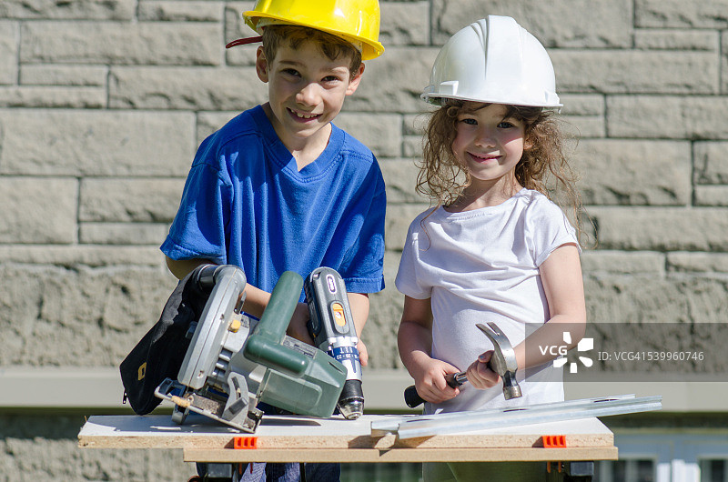 在户外玩大型工具的小男孩和小女孩图片素材