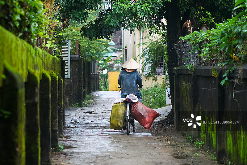 女子在小巷里骑自行车图片素材
